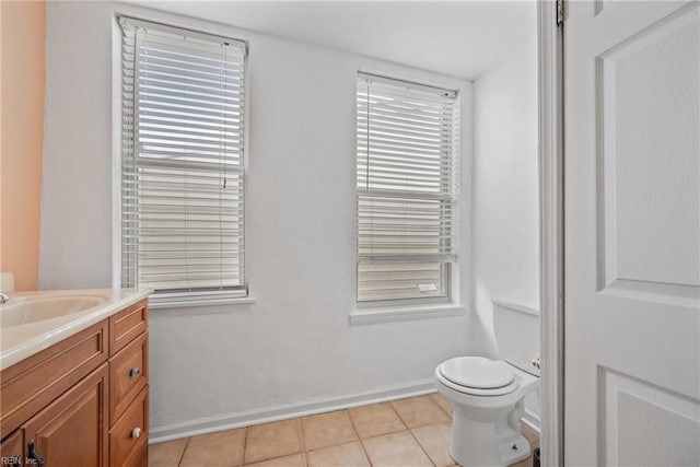 bathroom with toilet, vanity, tile patterned flooring, and baseboards