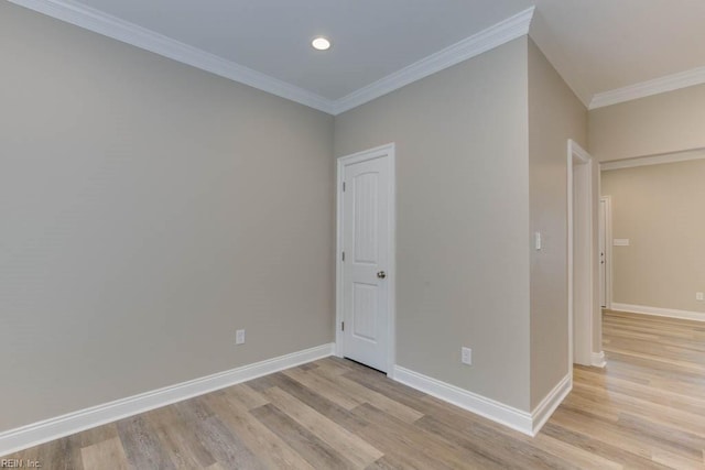 unfurnished room featuring light wood-style flooring, crown molding, and baseboards