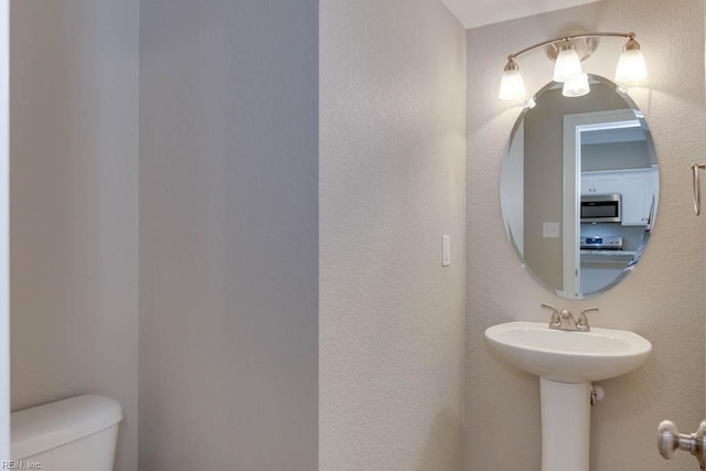 half bath featuring a sink and toilet
