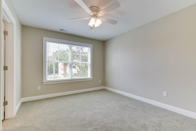 empty room with baseboards, visible vents, and carpet