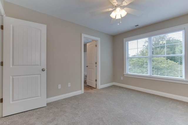 unfurnished bedroom with visible vents, a ceiling fan, ensuite bath, baseboards, and carpet flooring