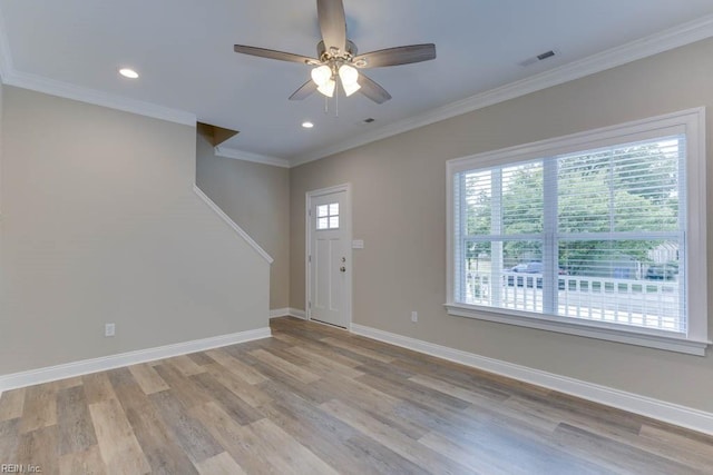 unfurnished living room with light wood finished floors, visible vents, ornamental molding, baseboards, and stairs