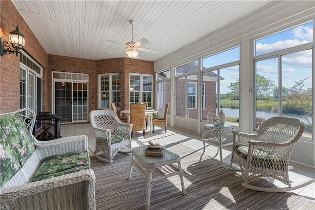 sunroom featuring a water view, ceiling fan, and an outdoor living space