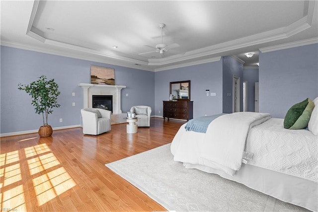 bedroom with a tray ceiling and wood finished floors