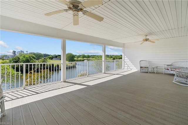 wooden terrace featuring a ceiling fan and a water view