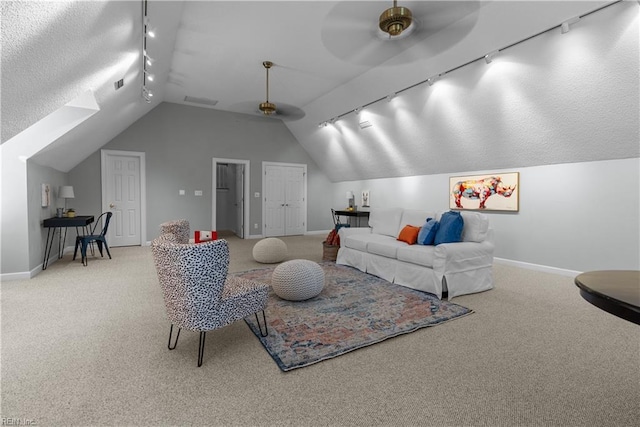 carpeted living area featuring baseboards, rail lighting, ceiling fan, and vaulted ceiling