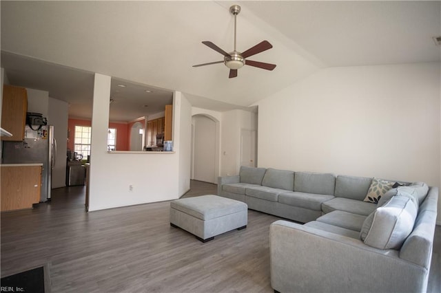 living room featuring arched walkways, ceiling fan, dark wood-style flooring, and lofted ceiling