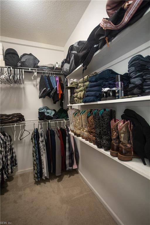 spacious closet featuring vaulted ceiling and carpet floors