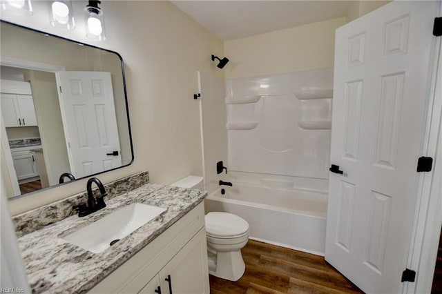 full bathroom featuring shower / washtub combination, wood finished floors, toilet, and vanity