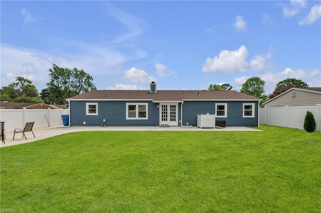 back of property featuring french doors, a patio area, a fenced backyard, and a lawn