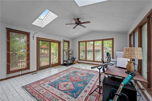office space featuring a wealth of natural light, vaulted ceiling with skylight, visible vents, and baseboards