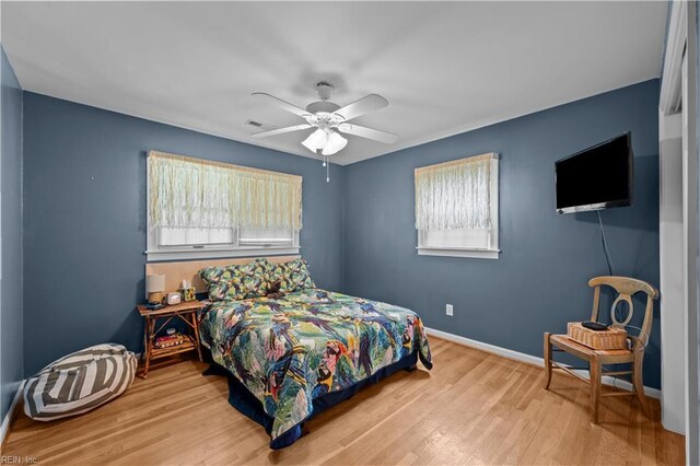 bedroom featuring ceiling fan, baseboards, wood finished floors, and visible vents