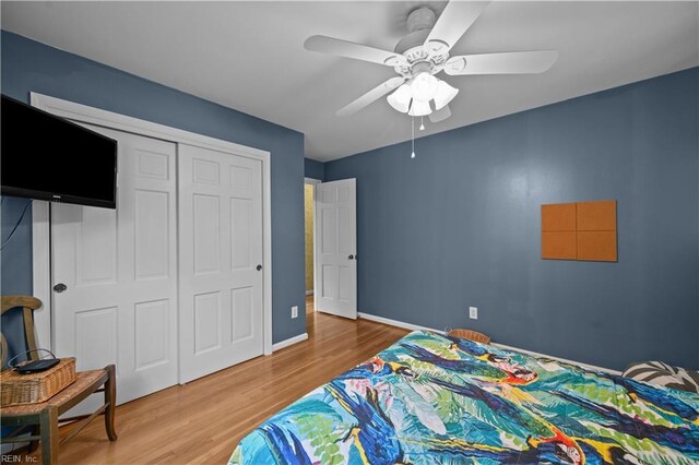bedroom featuring baseboards, wood finished floors, a closet, and ceiling fan