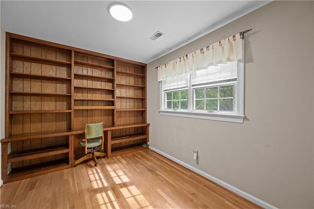 unfurnished room featuring light wood-style floors, visible vents, and baseboards