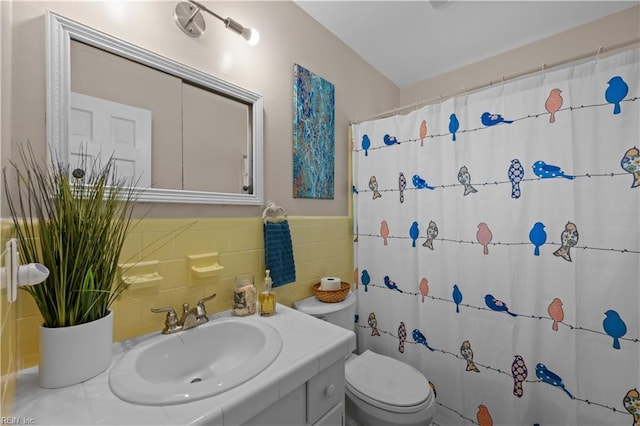 bathroom featuring toilet, vanity, curtained shower, and tile walls