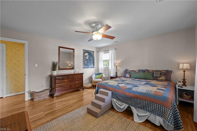 bedroom with ceiling fan, baseboards, and wood finished floors