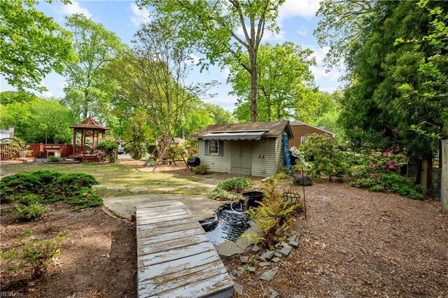 view of yard featuring fence, an outbuilding, and a gazebo
