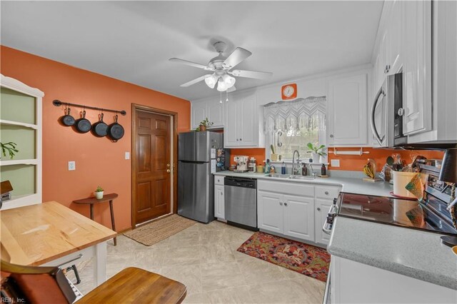 kitchen featuring white cabinets, a ceiling fan, a sink, and appliances with stainless steel finishes