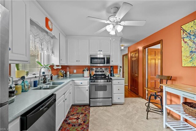 kitchen with white cabinets, light countertops, appliances with stainless steel finishes, and a sink