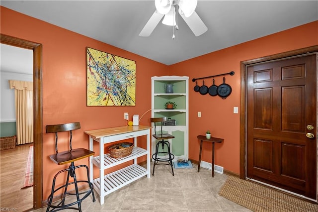 interior space featuring baseboards and a ceiling fan