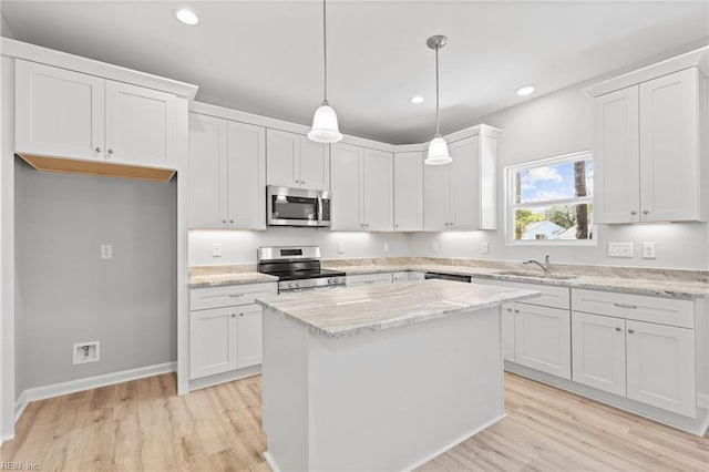 6471 Swan Arch, Norfolk, VA 23513 - kitchen featuring a sink, light wood-style floors, a kitchen island, white cabinets, and appliances with stainless steel finishes