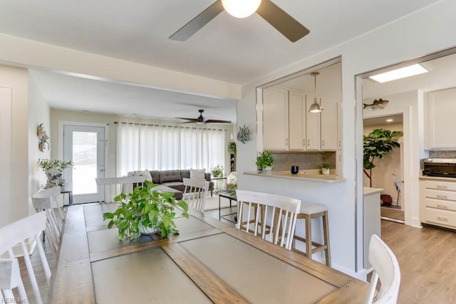 dining room with ceiling fan and light wood finished floors