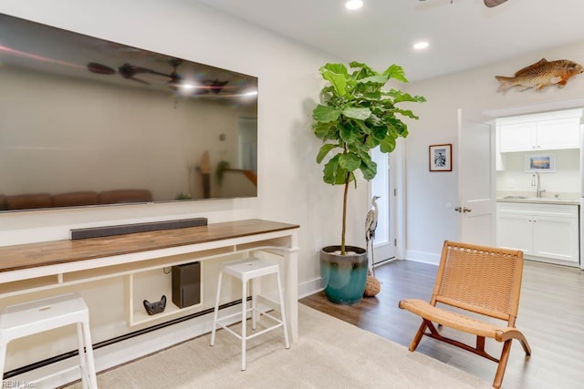living area featuring recessed lighting, light wood-type flooring, and baseboards