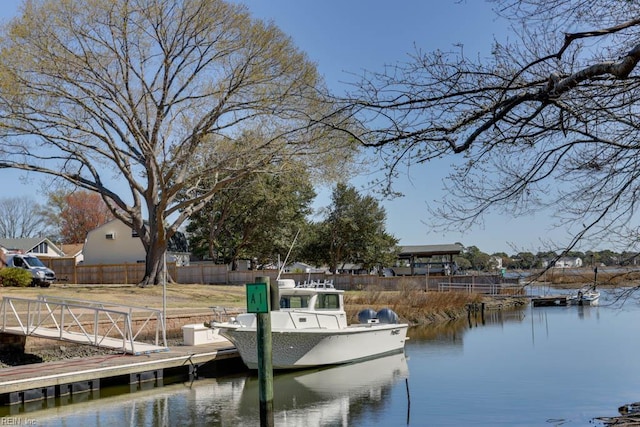 dock area with fence and a water view