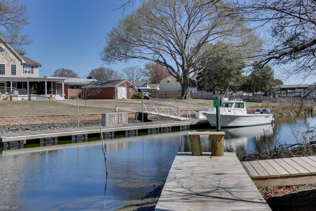 dock area with fence and a water view