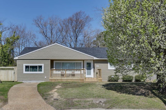 view of front of property with a porch, a shingled roof, and a front lawn