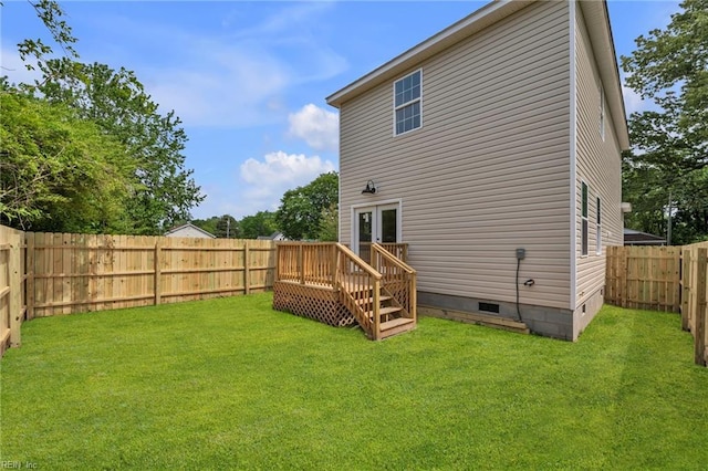 rear view of property featuring french doors, a lawn, crawl space, and a fenced backyard