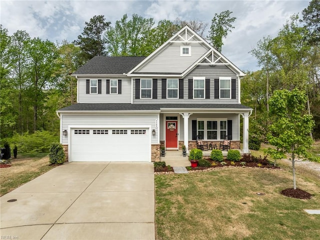craftsman-style home featuring an attached garage, covered porch, a front yard, and concrete driveway