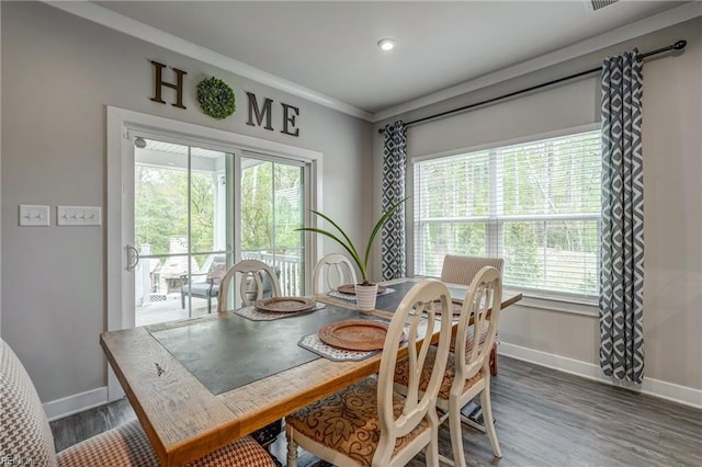dining space with crown molding, baseboards, a healthy amount of sunlight, and wood finished floors