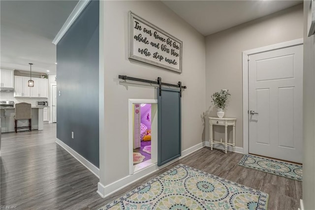 entrance foyer with a barn door, baseboards, dark wood-style flooring, and recessed lighting