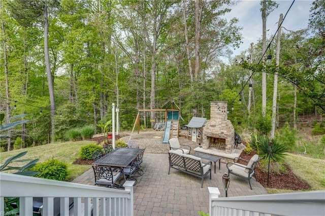 view of patio featuring an outdoor living space with a fireplace and a playground