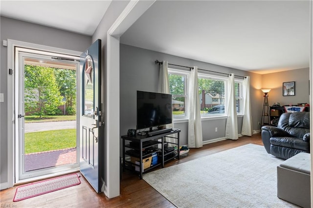 living area with baseboards and wood finished floors