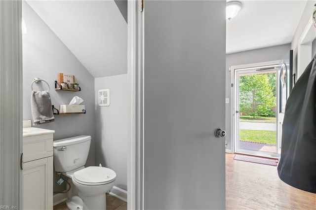 bathroom featuring lofted ceiling, vanity, and toilet