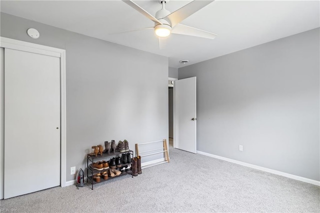 carpeted bedroom with ceiling fan, baseboards, and a closet