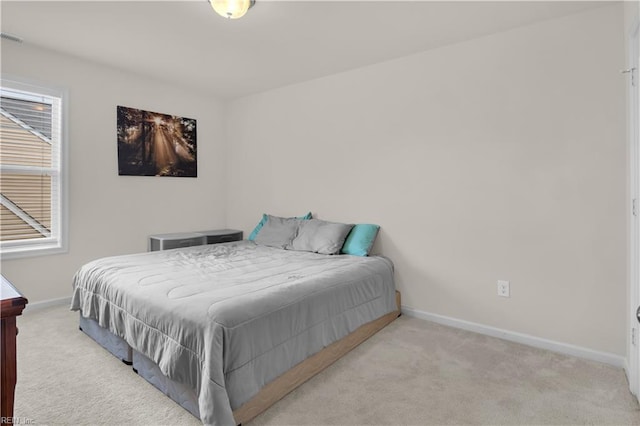bedroom with baseboards and light carpet