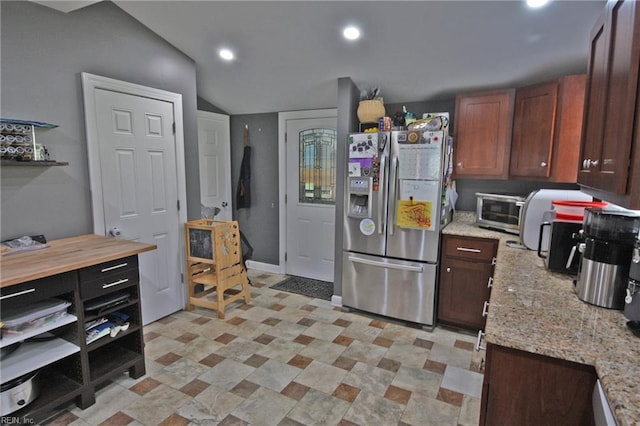 kitchen with stainless steel fridge with ice dispenser, a toaster, lofted ceiling, light stone countertops, and recessed lighting