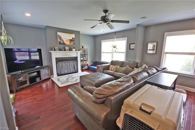 living room featuring ceiling fan, wood finished floors, a fireplace with raised hearth, and recessed lighting