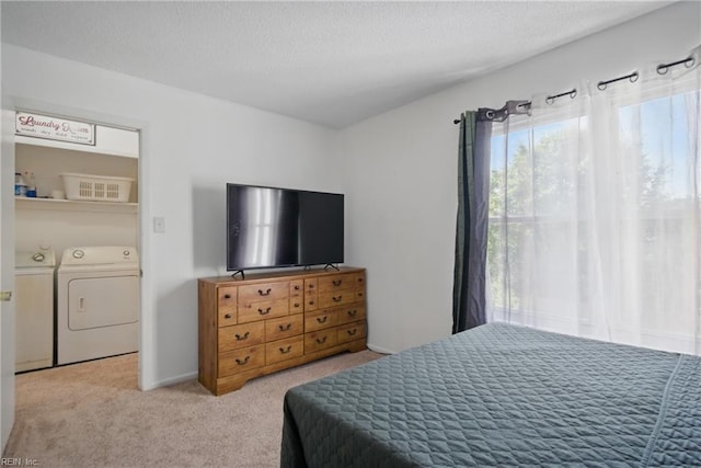 carpeted bedroom with a textured ceiling and independent washer and dryer