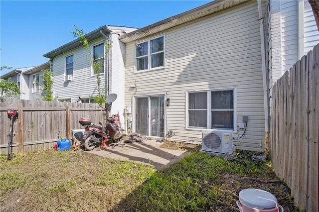 rear view of house with a fenced backyard and ac unit