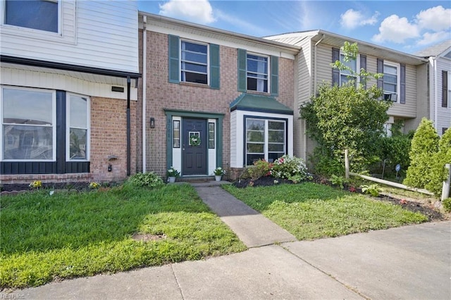 view of front of home featuring a front yard and brick siding