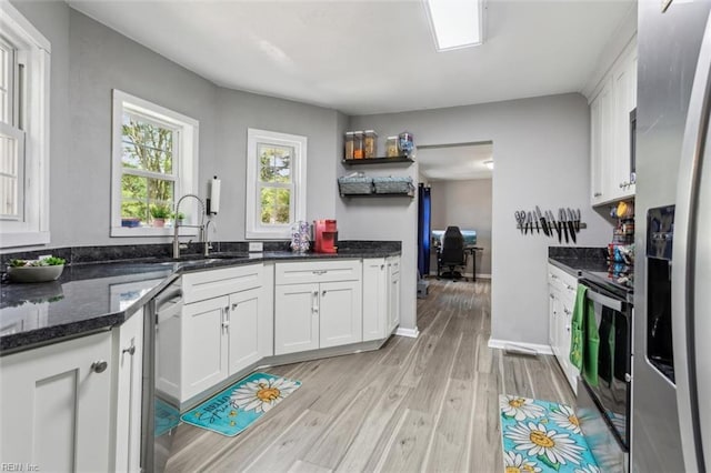 5933 Madison Ave, Newport News, VA 23605 - kitchen featuring white cabinets, light wood-style flooring, stainless steel appliances, and a sink