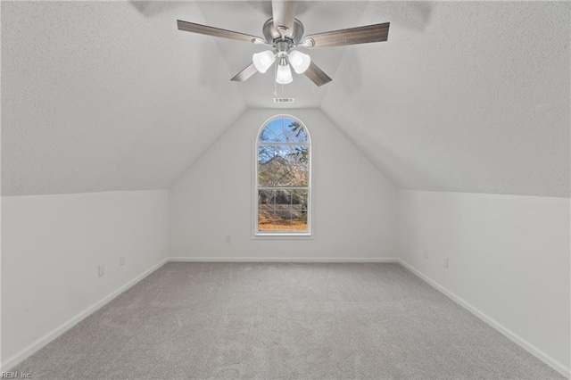 bonus room with vaulted ceiling, a textured ceiling, carpet flooring, and baseboards