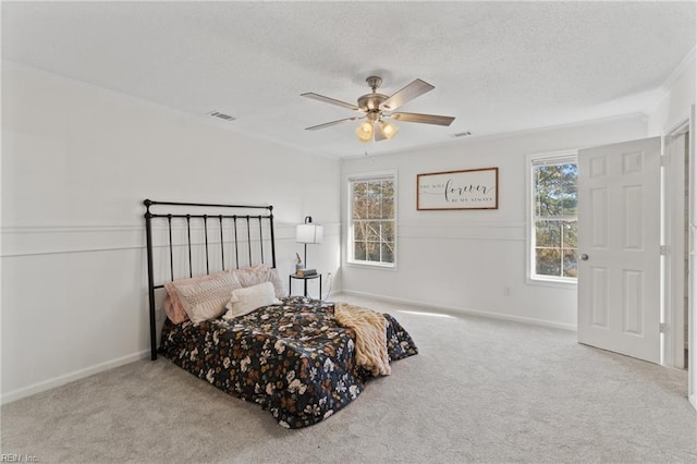 bedroom with a ceiling fan, a textured ceiling, carpet, baseboards, and visible vents