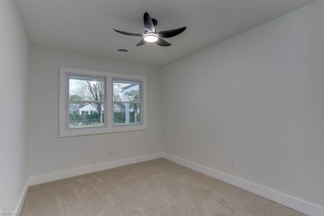 unfurnished room featuring light carpet, a ceiling fan, visible vents, and baseboards