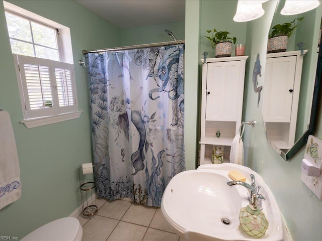 full bath with toilet, tile patterned floors, curtained shower, and a sink