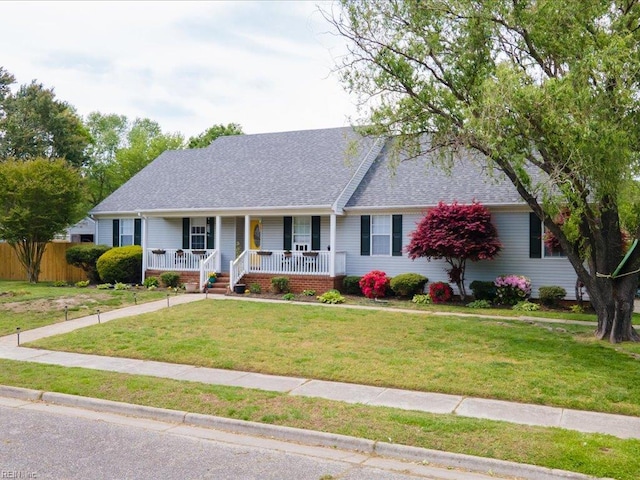 ranch-style home with a front lawn, roof with shingles, fence, and covered porch